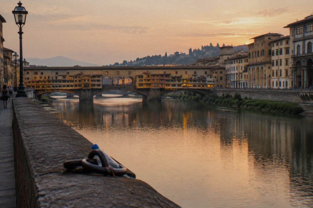 Evening light on the Arno river with the Ponte Vecchio and the hill of Piazzale Michelangelo beyond