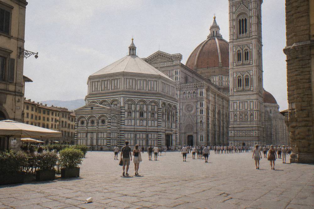 High view across the piazza of Florence Cathedral in Italy on a hazy summer afternoon, Giotto's striped marble bell tower beside the dome, Piazza del Duomo